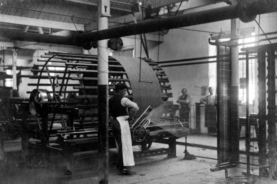 black and white image of a man in a mill working taking in the early 1900s