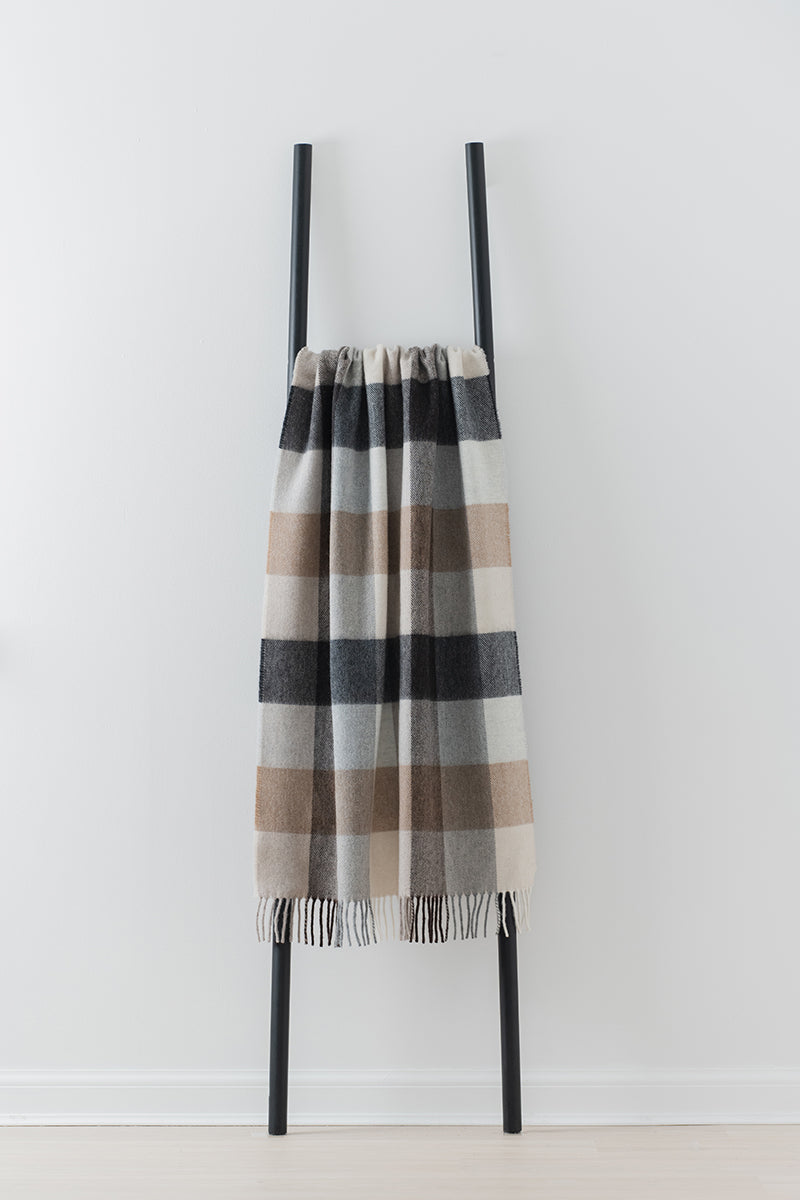 Remony dunira natural throw - Checkered scarf on a black stand against a white background