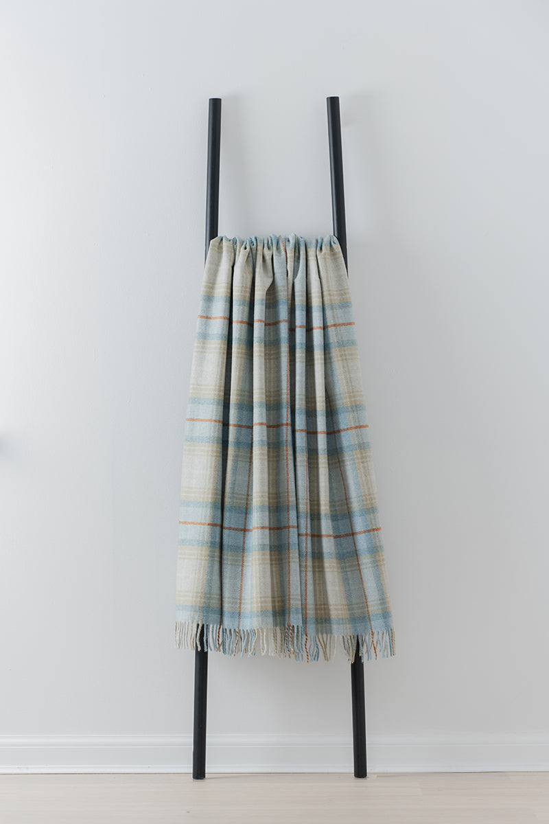 Remony Lindores Caramel throw - Plaid blanket draped over a black metal ladder against a white wall.