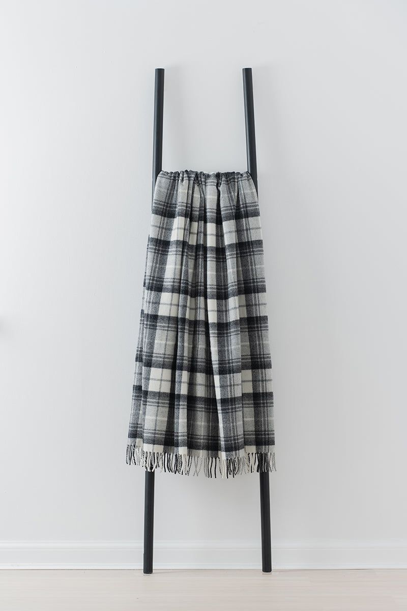 Remony lindores slate throw - Plaid blanket with fringe on a black ladder against a white background