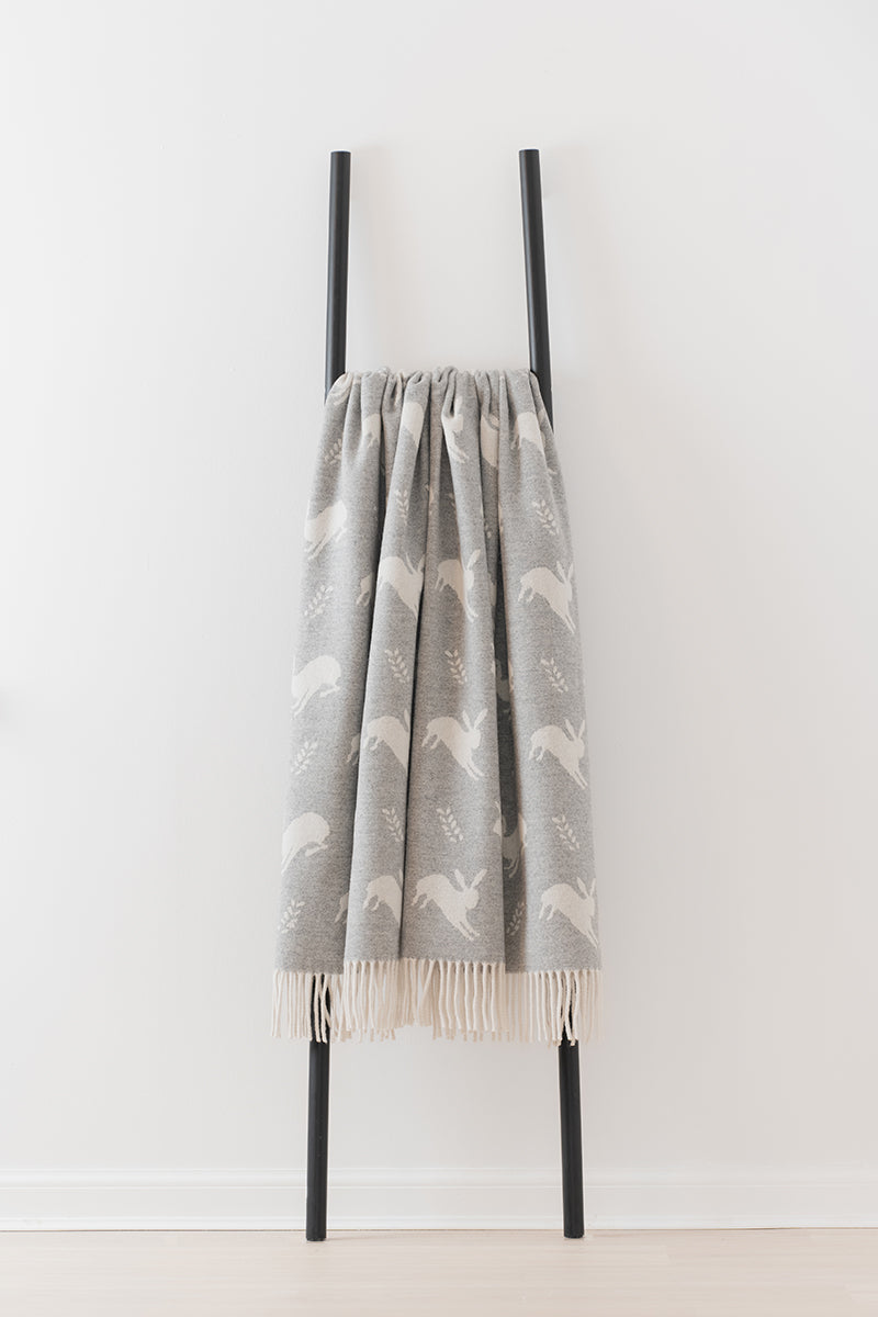Remony Nature Hare grey patterned blanket draped over a black metal ladder on a white background