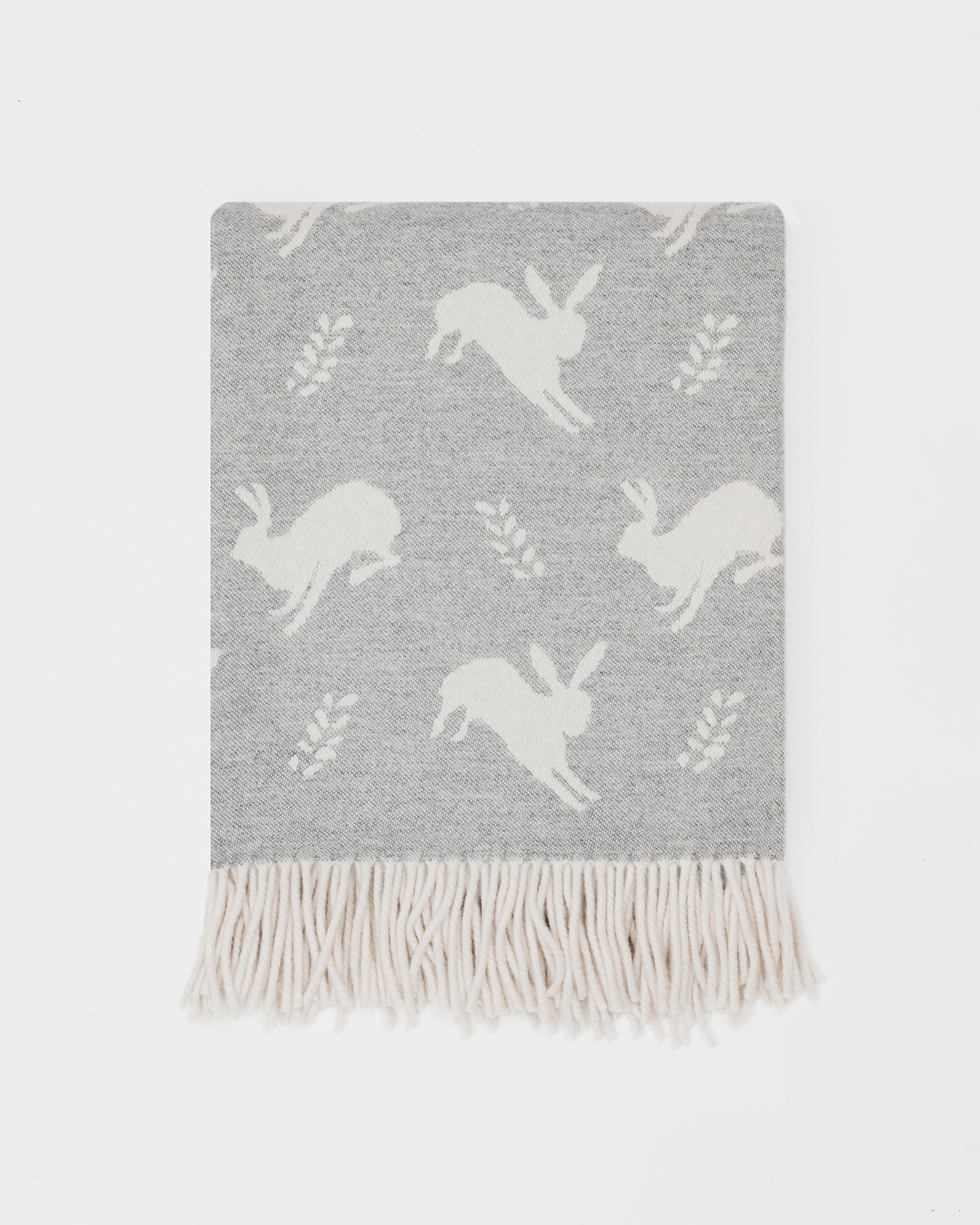 Remony nature hare grey blanket with white unicorn patterns and fringes on a light gray background