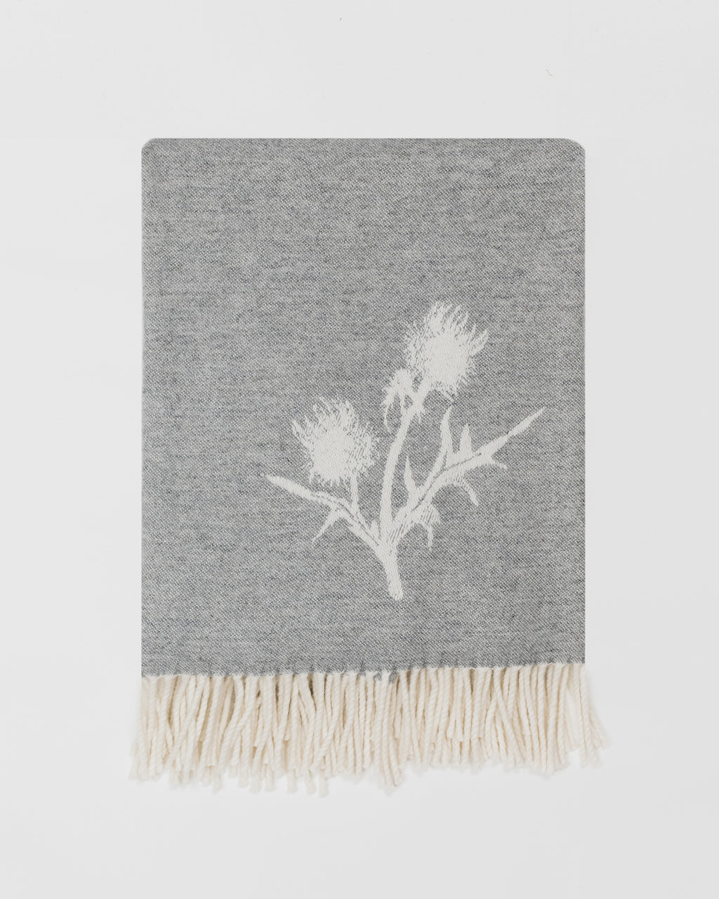 Remony nature thistle and bee grey blanket with white floral design and fringes on a light grey background
