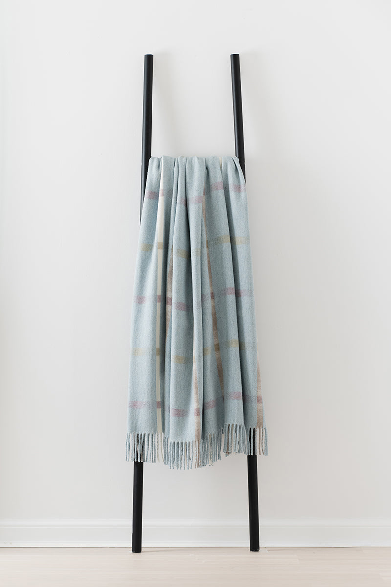 Remony maree arctic throw - check scarf draped over a black rack against a white background