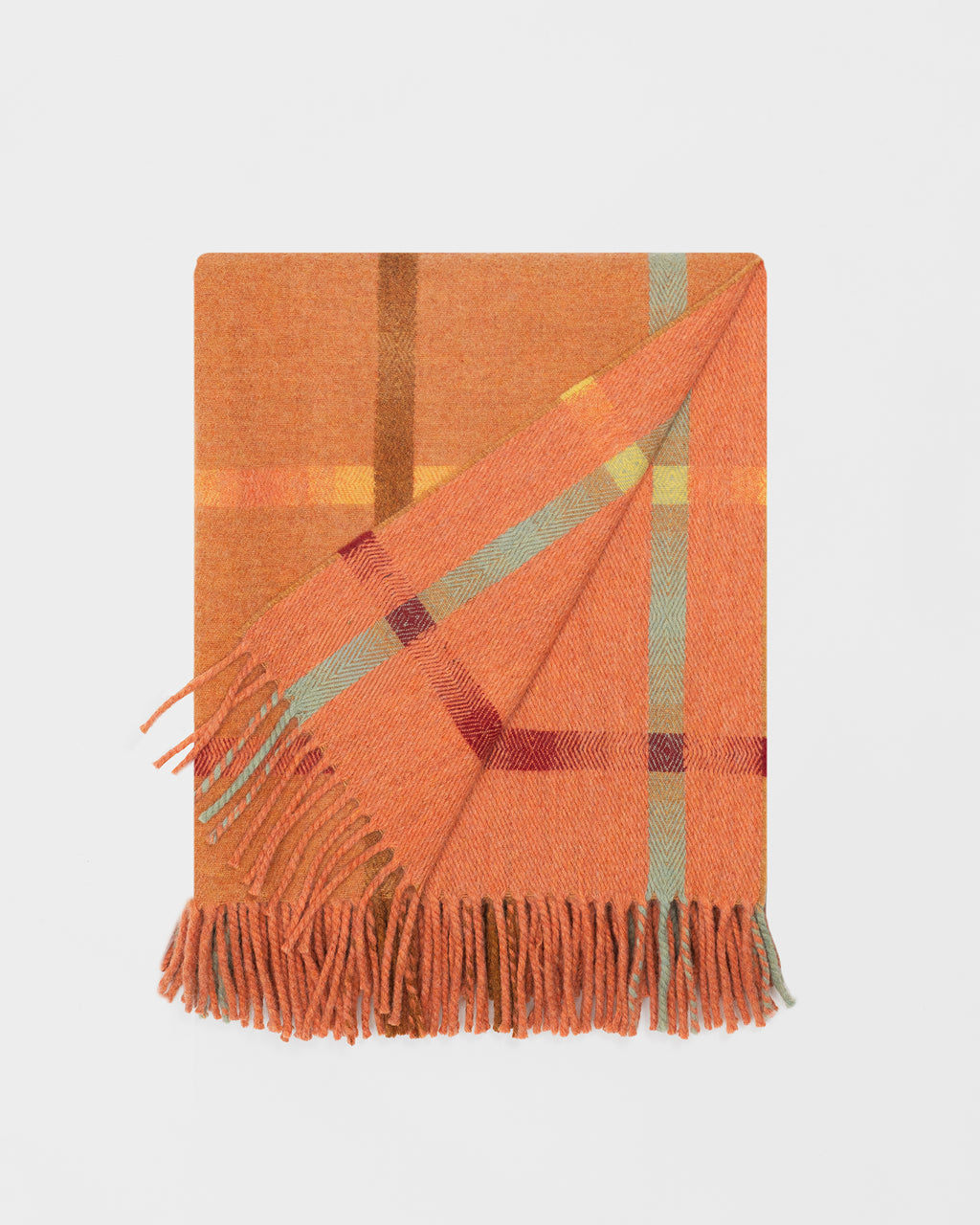 Remony maree spice throw - Orange plaid blanket with fringes on a light gray background