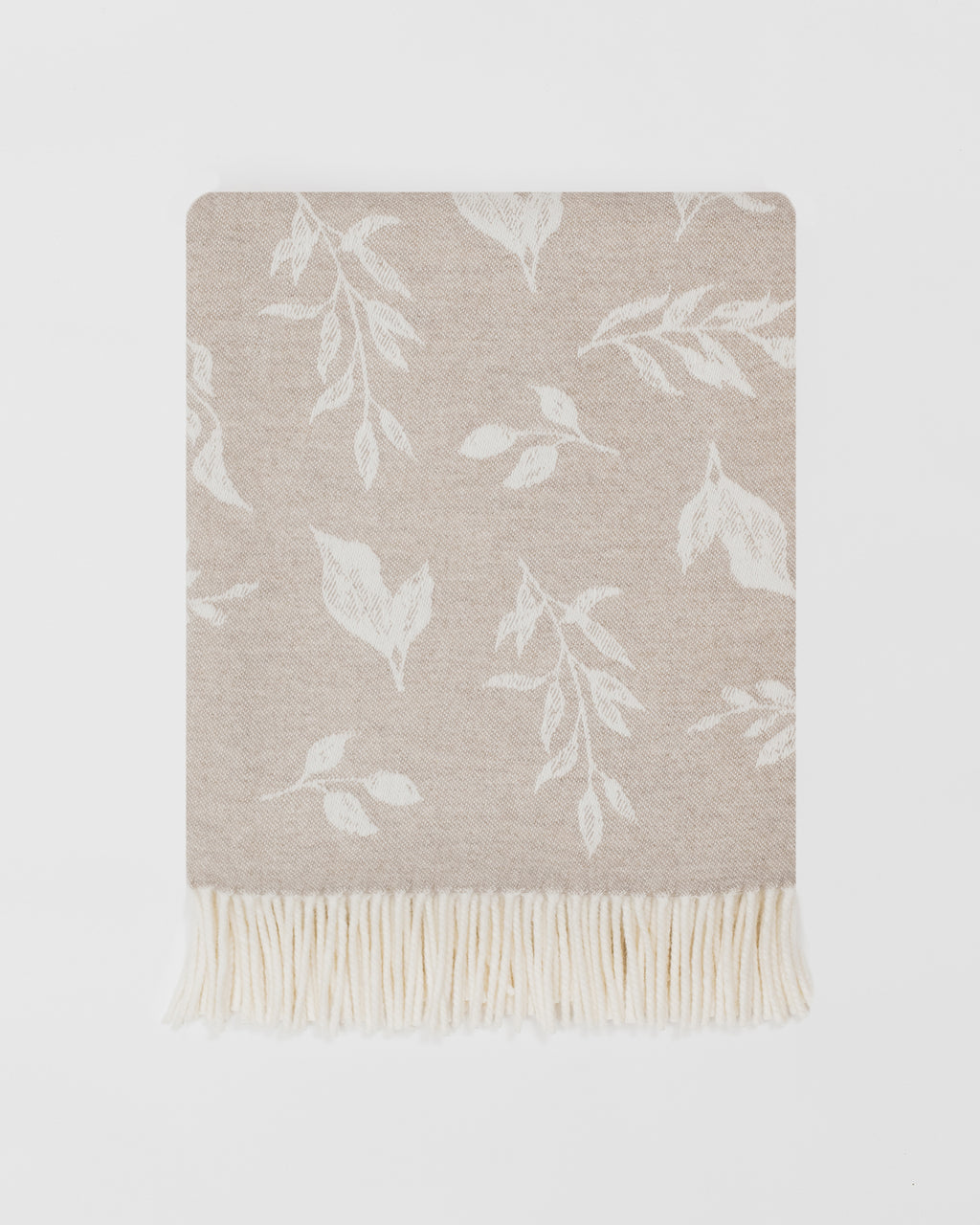 Remony nature leaf oatmeal throw - Beige throw blanket with white leaf pattern on a light gray background