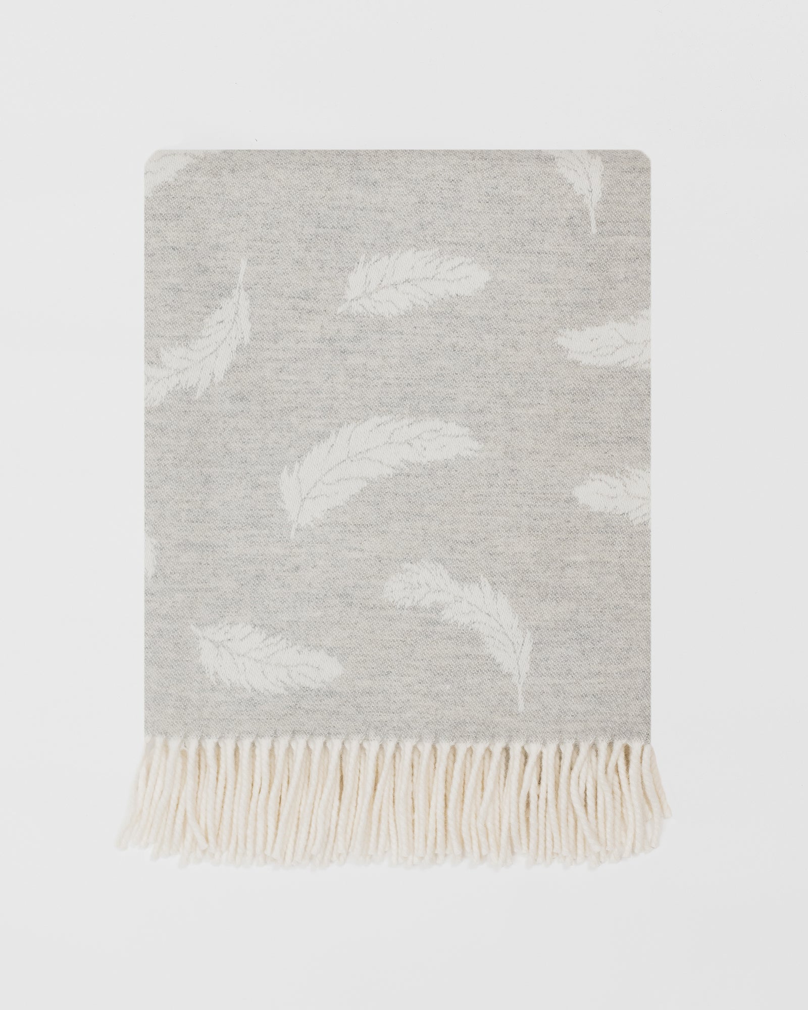 Remony Nature Feather silver grey blanket with white cloud pattern and fringed edge on a light grey background