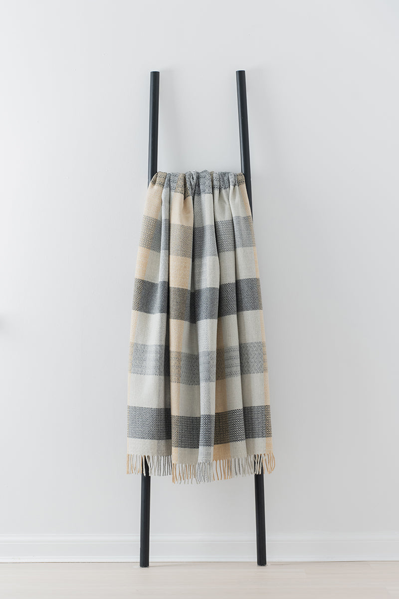 Remony patchwork croft throw - Plaid blanket draped over a black metal frame against a white background