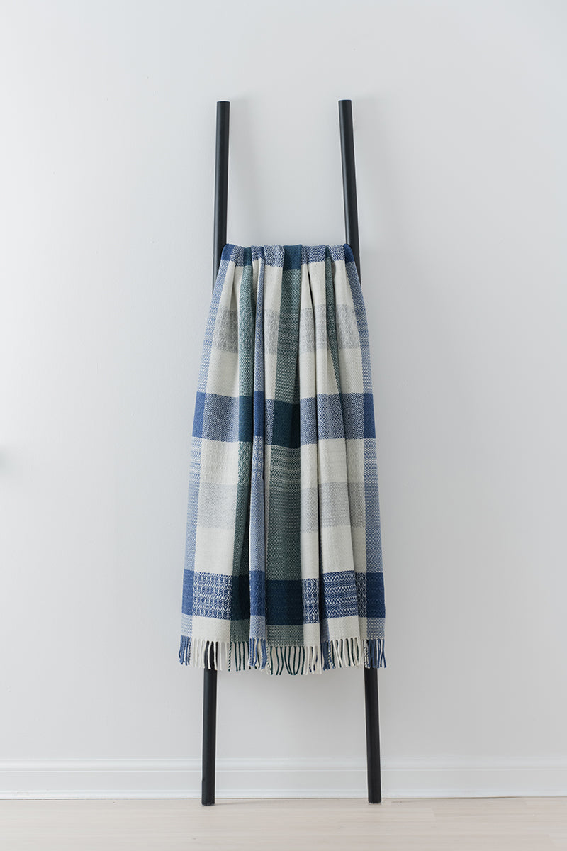 Remony patchwork moonlight throw - draped over a black metal ladder on a white background