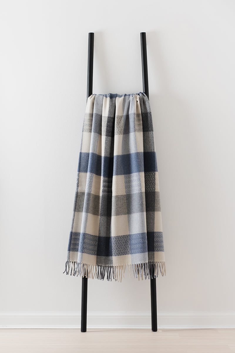 Remony coastline throw - blanket draped over a black metal frame against a white background