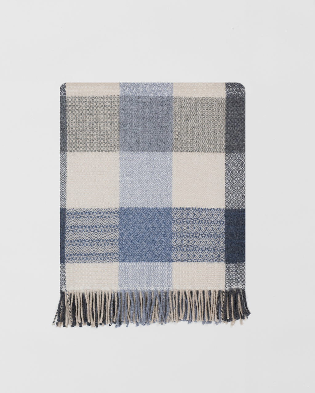 Remony coastline throw - blanket with blue, gray, and beige colors on a light gray background