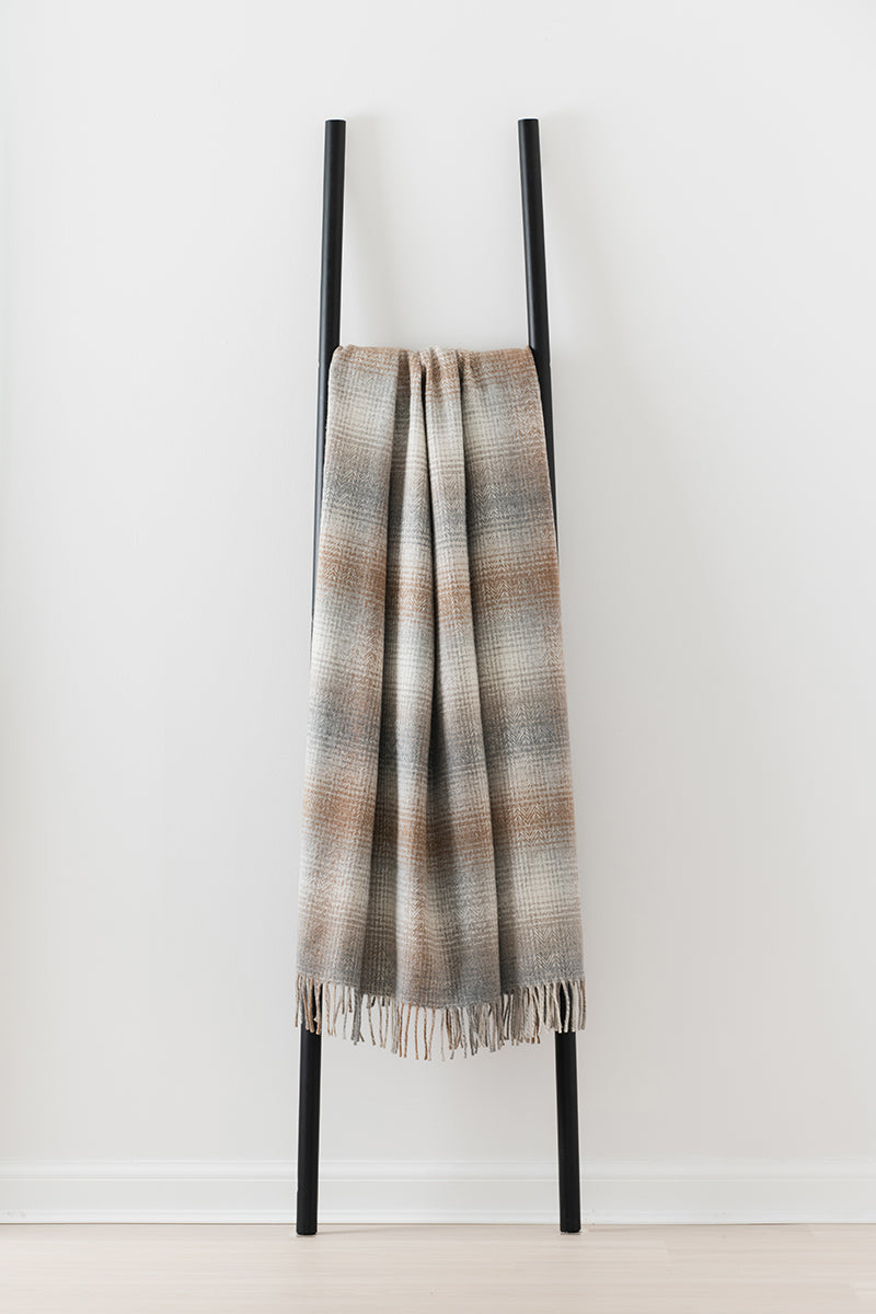 Remony lunan bracken throw - Textured blanket draped over a black metal ladder on a white background