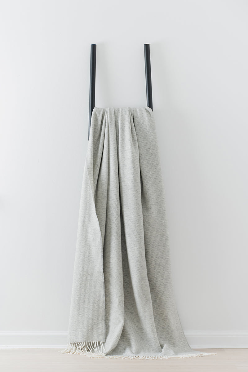 Remony Clova Silver large throw - blanket draped over black ladders on white background