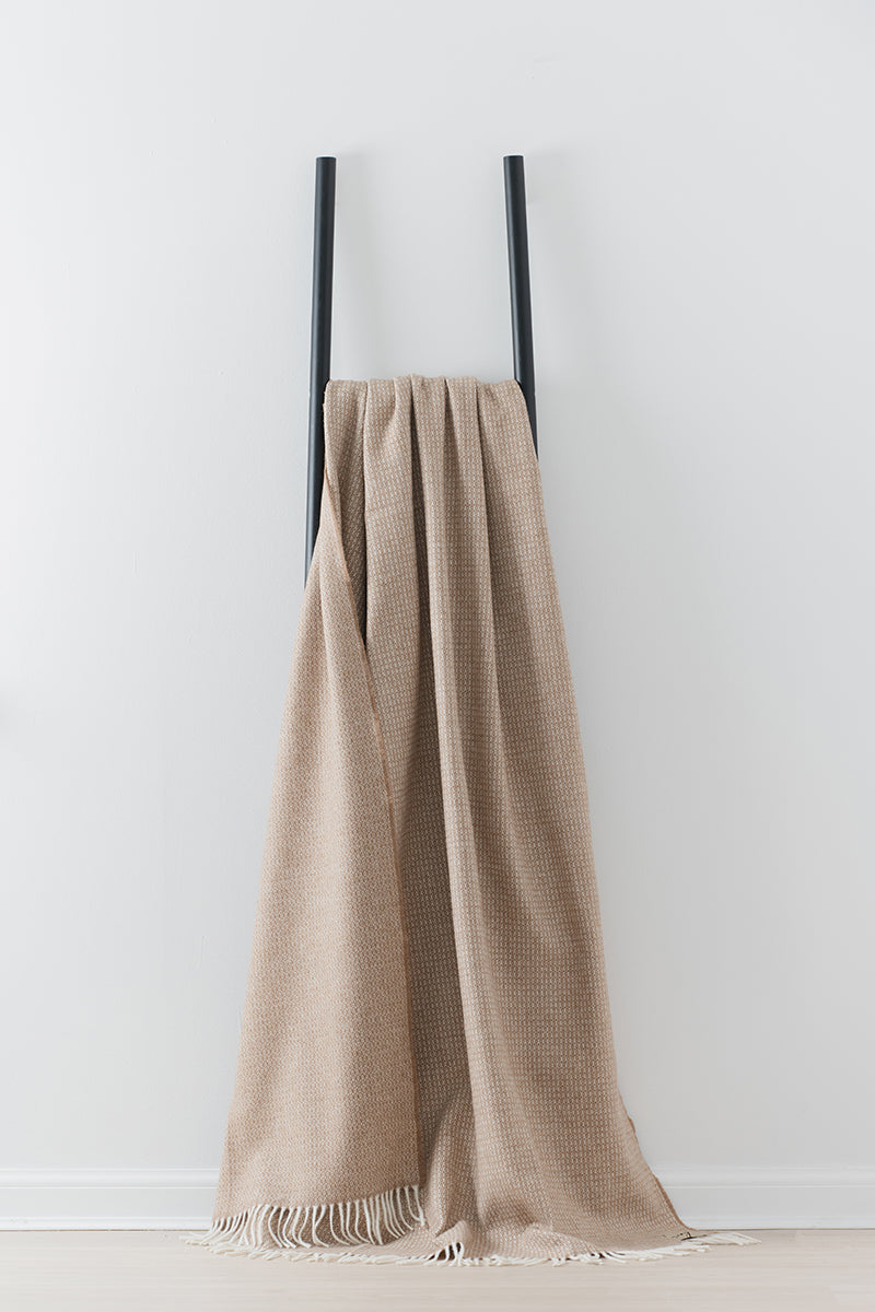 Remony Clova Vicuna large throw - blanket draped over black ladder on white background
