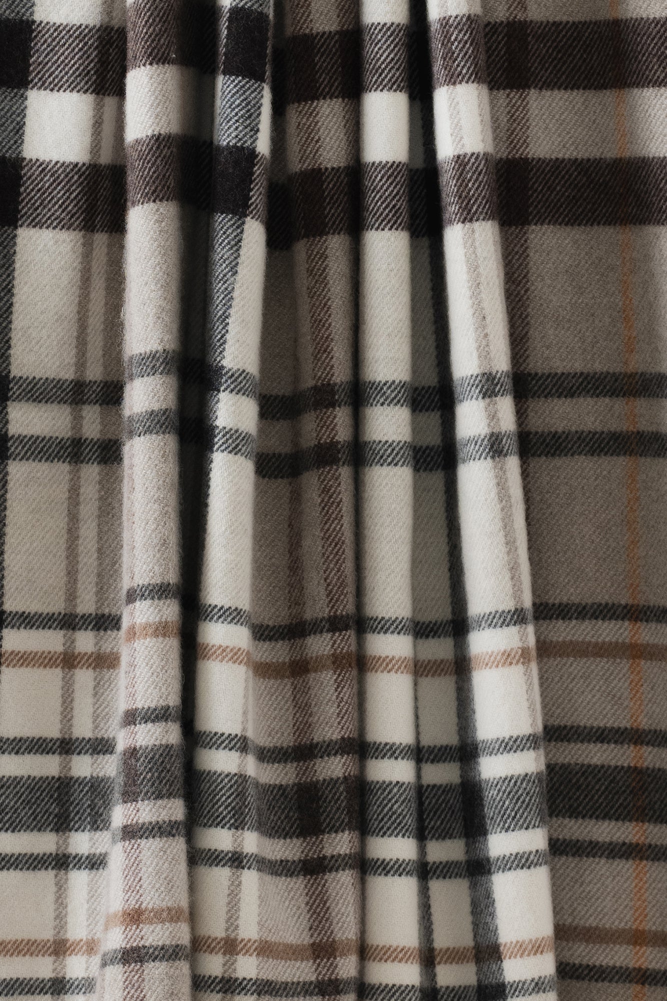 Remony pitnacree stone stole Close-up of plaid fabric with brown, beige, and black colors.