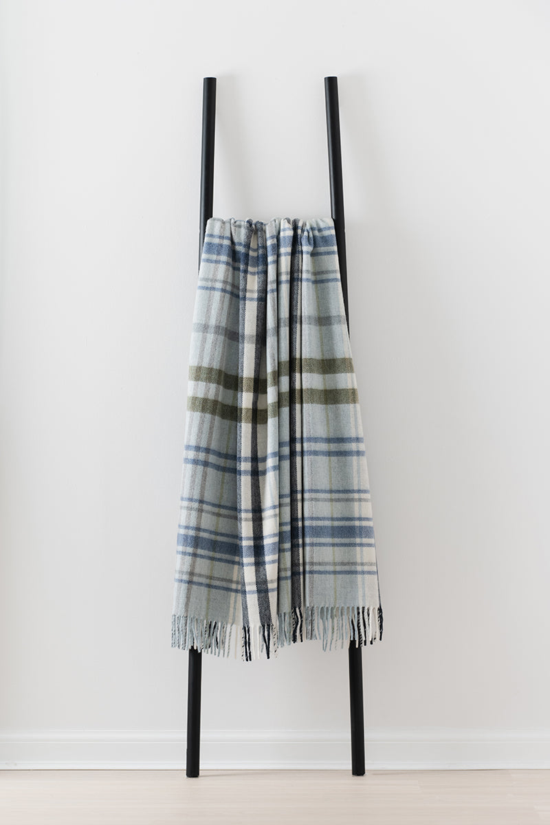 Remony pitnacree sea blue throw - blanket draped over a black ladder on a white background