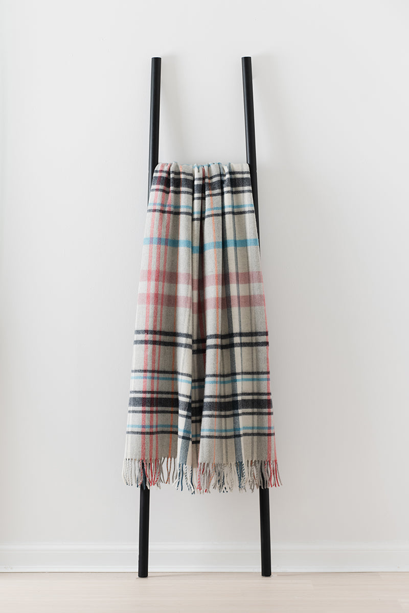 Remony pitnacree rose throw - check blanket on a black ladder against a white background