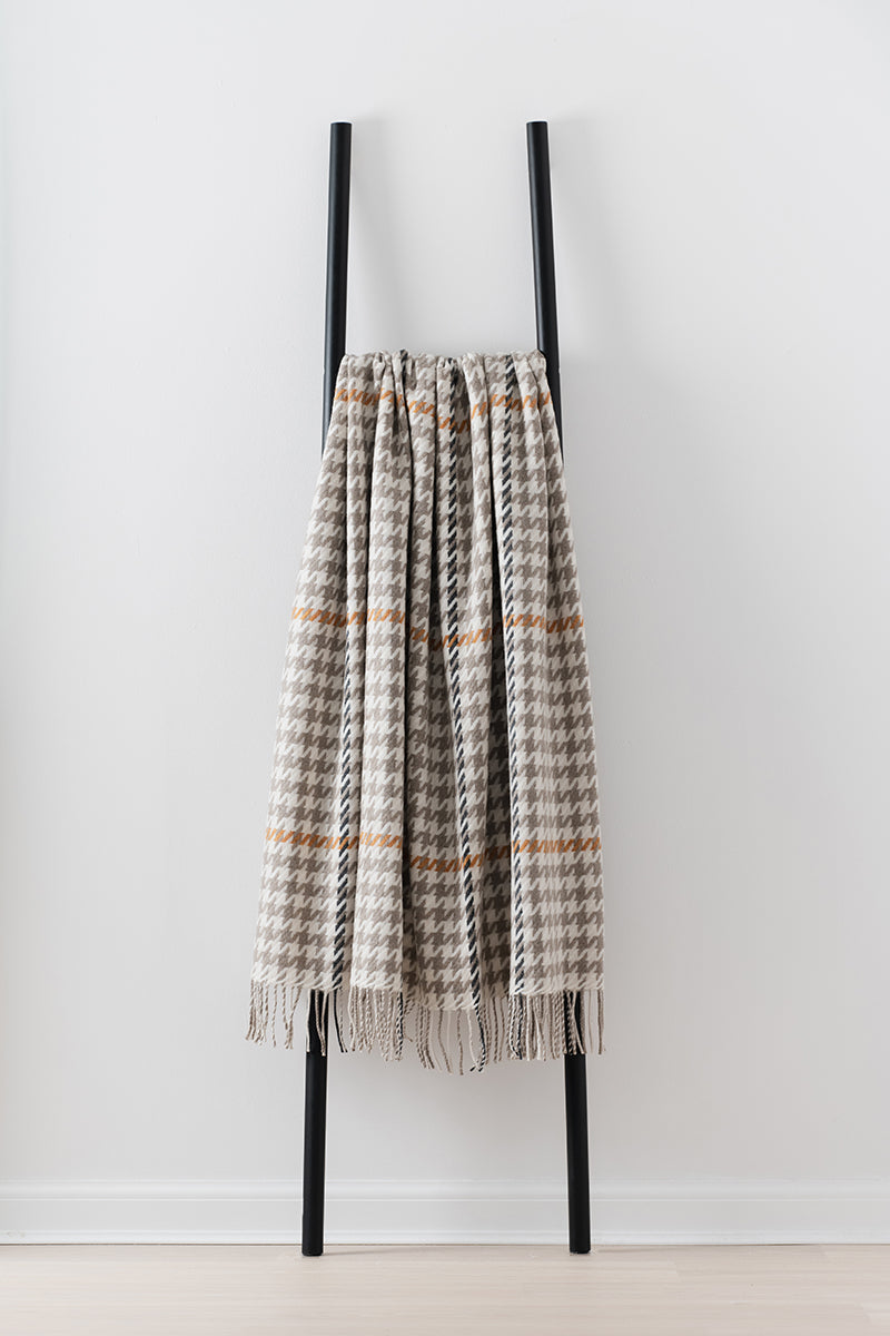 Remony carroglen mushroom throw - Plaid blanket draped over a black metal ladder on a white background