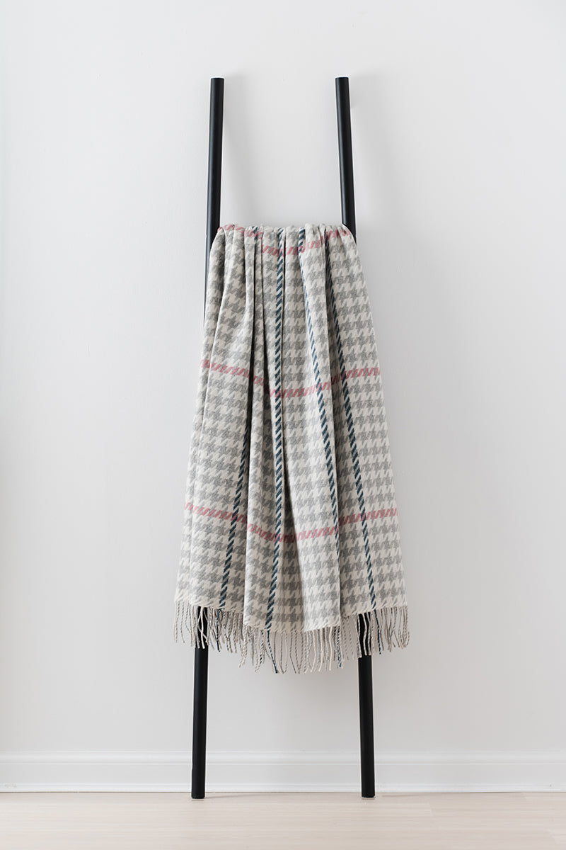 Remony carroglen silver throw - blanket draped over a black metal ladder on a white background