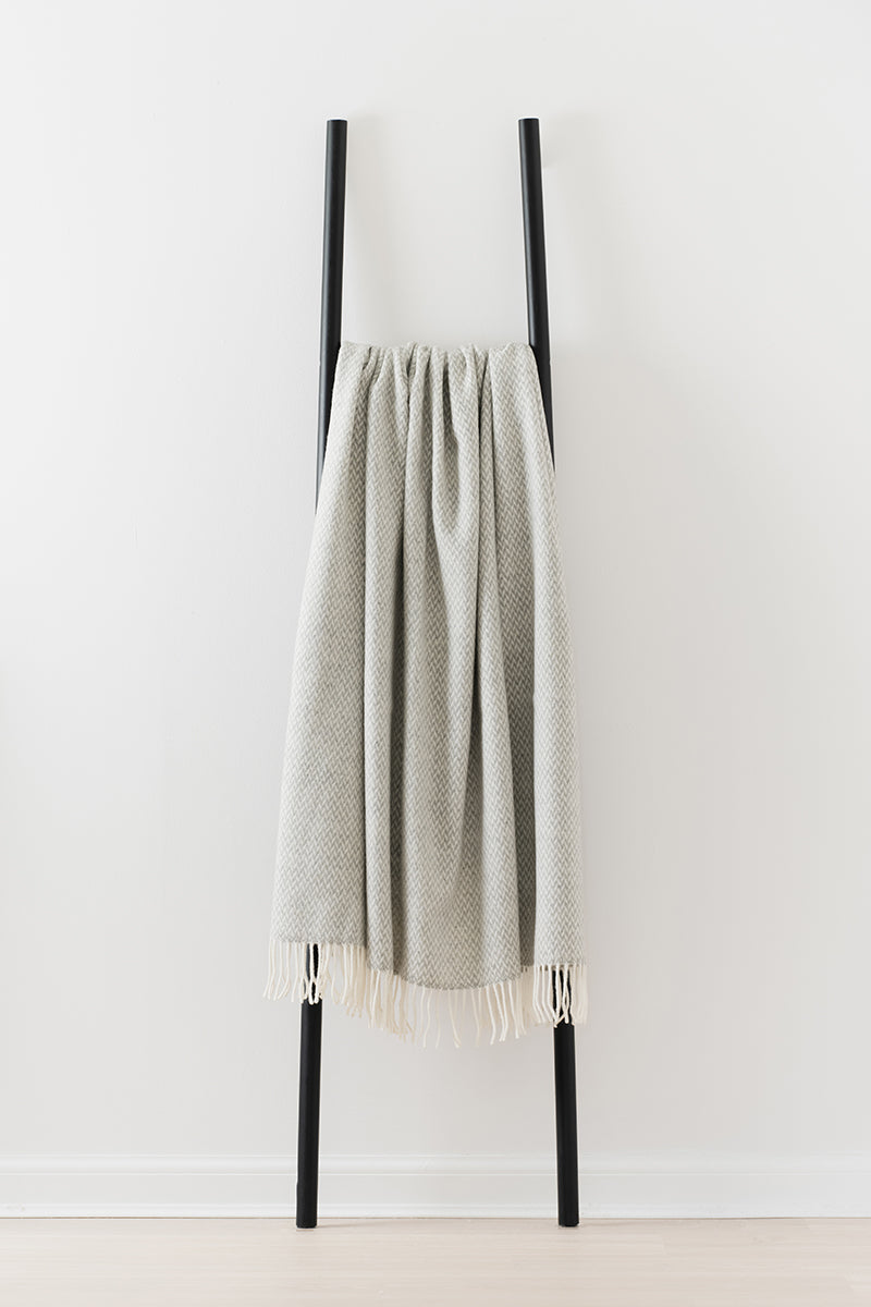 Remony balintyre cloud throw - Textured blanket draped over a black metal rack against a white background