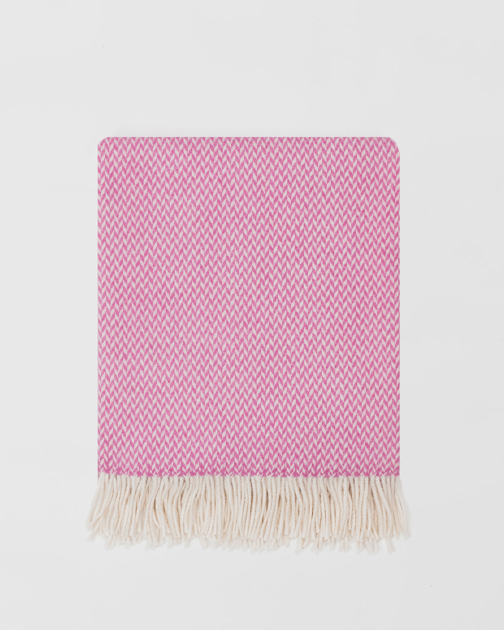 Remony balintyre foxglove throw - Pink woven blanket with white fringe on a light gray background