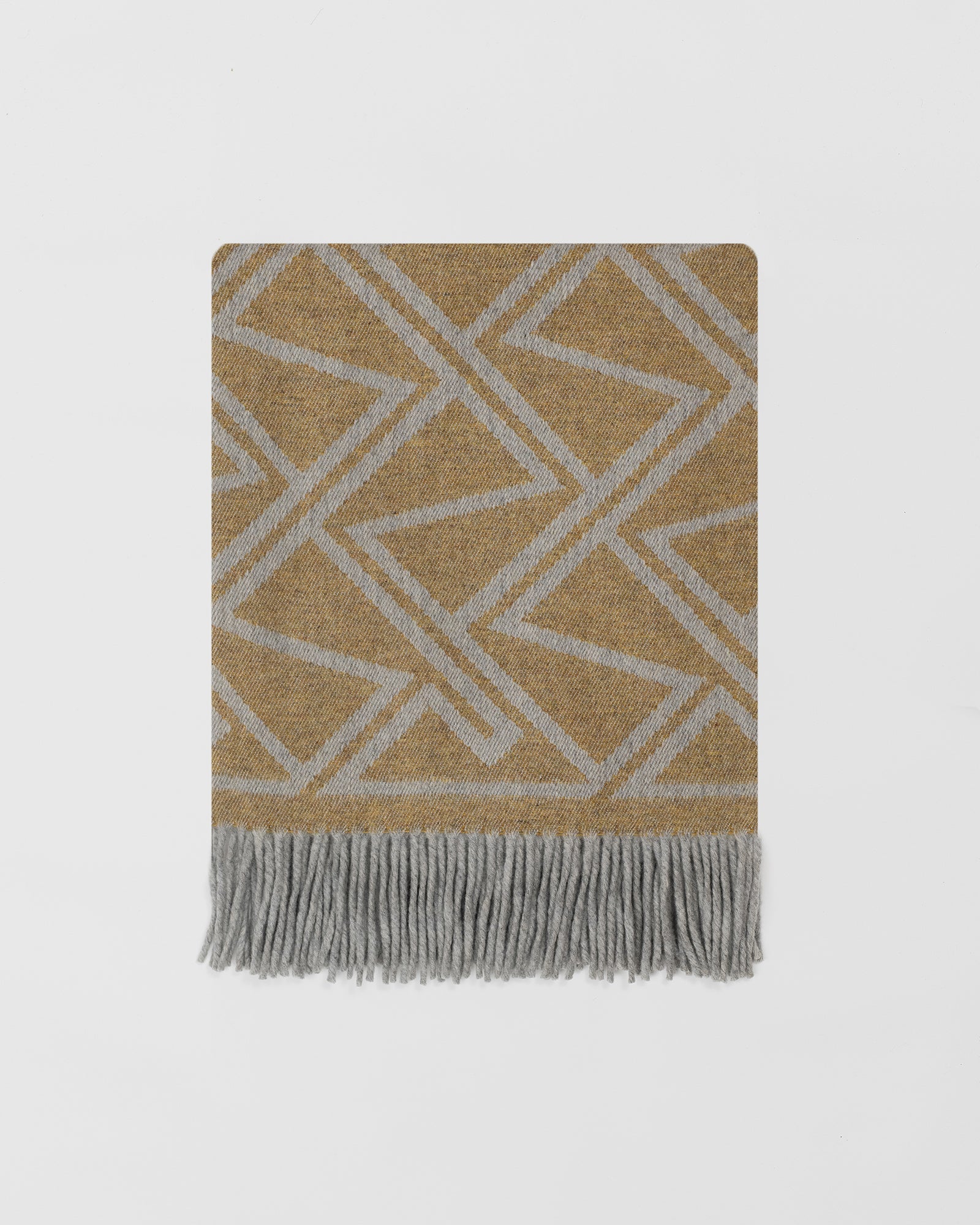 Remony fortriu mead throw - geometric patterned throw blanket with fringes on a light gray background